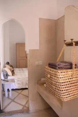 a bedroom with a bed and a basket on a shelf at Riad Miski in Marrakech