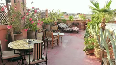 a patio with tables and chairs and potted plants at Riad Miski in Marrakech