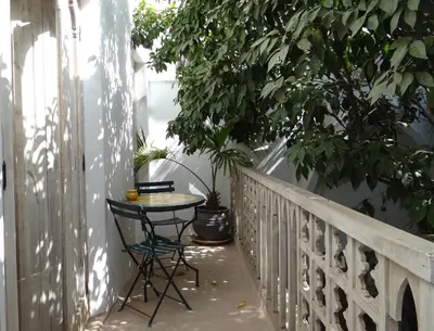 a table and chair on a balcony with a tree at Riad Safa in Marrakech