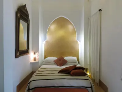 a bedroom with a bed with a gold headboard at Riad Safa in Marrakech