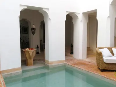 a room with a pool in a house with white columns at Riad Safa in Marrakech