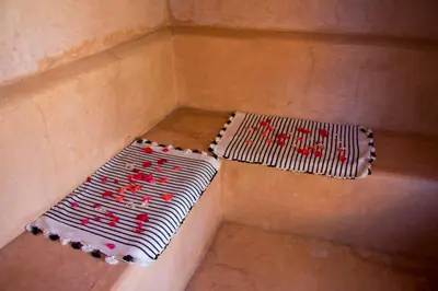 a corner of a room with a bench with red writing at Riad Safa in Marrakech