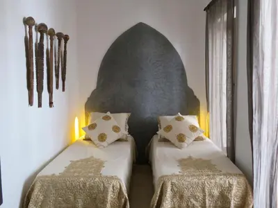two beds in a room with two tables at Riad Safa in Marrakech