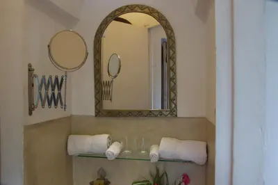 a bathroom with a sink with a mirror and towels at Riad Safa in Marrakech