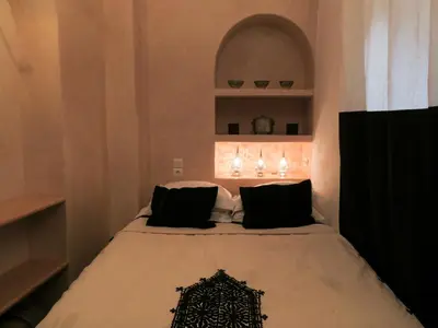 a bedroom with a bed with black pillows at Riad Safa in Marrakech