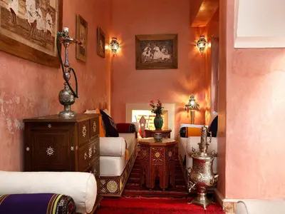 a living room with orange walls and white furniture at Riad Julia in Marrakech