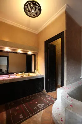 a bathroom with a sink and a large mirror at Riad Monceau in Marrakech