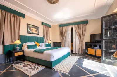 a bedroom with a large bed and a television at Janat Al Atlas Resort & Spa in Marrakech