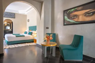 a hotel room with a bed and a table and chairs at Janat Al Atlas Resort & Spa in Marrakech