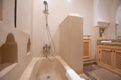 a bathroom with a bath tub with a shower at Janat Al Atlas Resort & Spa in Marrakech