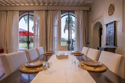 a dining room with a long table and white chairs at Janat Al Atlas Resort & Spa in Marrakech