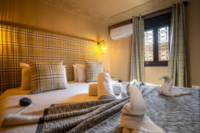 a bedroom with a bed with two animals on it at Dar Khmissa Riad & Spa in Marrakech