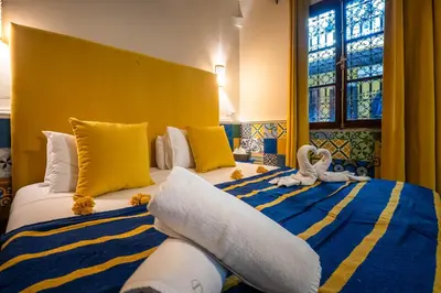 a hotel room with two beds with towels on them at Dar Khmissa Riad & Spa in Marrakech