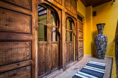a large wooden door with a vase next to it at Dar Khmissa Riad & Spa in Marrakech