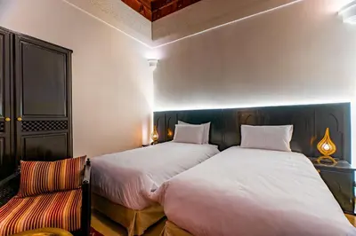 a bedroom with two beds and a couch at Riad Dar Dialkoum in Marrakech