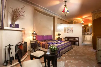 a bedroom with a bed and a fireplace at Riad Turquoise in Marrakech