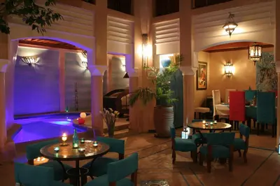 a restaurant with tables and chairs and purple lighting at Riad Turquoise in Marrakech