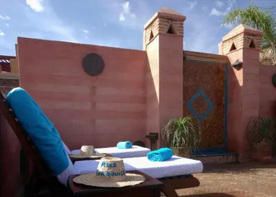 a patio with two lounge chairs and a building at Riad Turquoise in Marrakech
