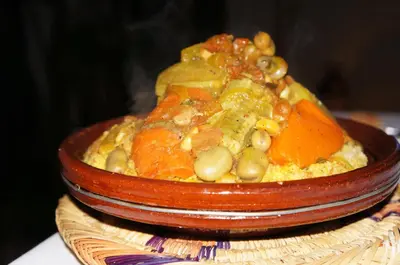 a bowl of food with beans and carrots on a table at Riad Shanima SPA Marrakech in Marrakech