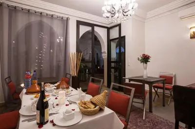 a dining room with a table and chairs and a chandelier at Riad Shanima SPA Marrakech in Marrakech