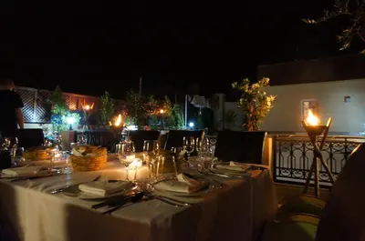 a long table with a white table cloth and candles at Riad Shanima SPA Marrakech in Marrakech
