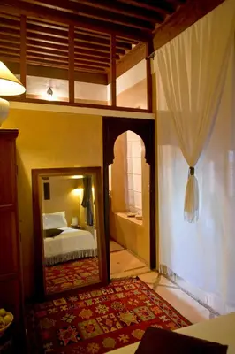 a bedroom with a mirror and a bed and a bed sqor at Dar Attajmil in Marrakech