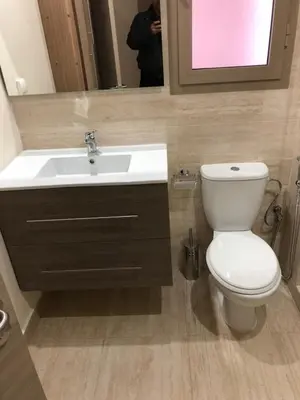 a bathroom with a white toilet and a sink at Appartement à Prestigia Marrakeche avec jardin in Marrakech