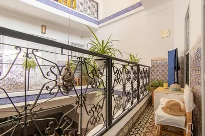 a balcony with a table and a bed in a room at Riad Medina in Marrakech