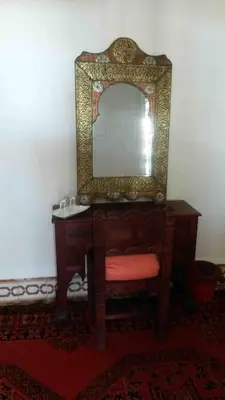 a dressing table with a mirror and a red stool at Riad Medina in Marrakech