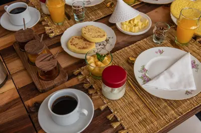 a wooden table with plates of food and a cup of coffee at Riad la Parenthèse by Sashema in Marrakech