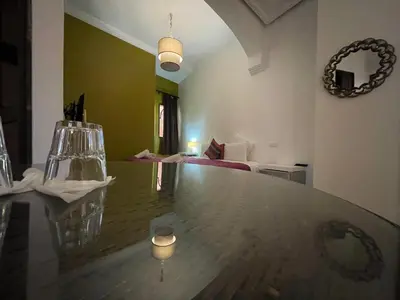 a dining room with a table and a living room at Riad Samarine in Marrakech