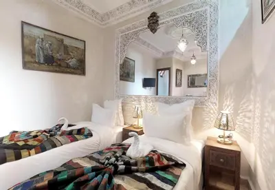 two white beds in a room with a mirror at Riad Sania By Ghali in Marrakech