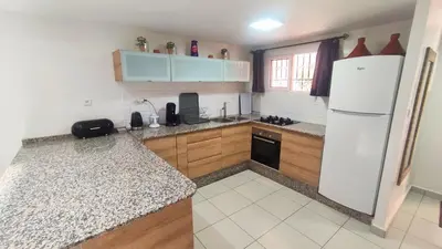 a kitchen with a white refrigerator and wooden cabinets at Riad Abdou in Marrakech