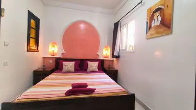a bedroom with a bed with a red towel on it at Riad Abdou in Marrakech