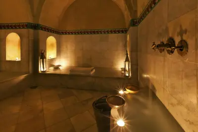 a bathroom with a tub and a sink with lights at Le Farnatchi in Marrakech