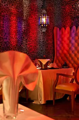 a restaurant with a table and chairs and a chandelier at Le Farnatchi in Marrakech