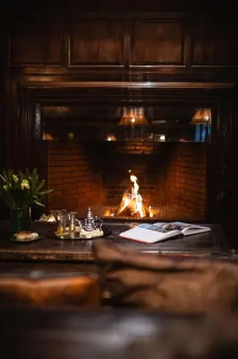 a fireplace in a room with a table with a fire at La Villa des Orangers - Relais & Châteaux in Marrakech