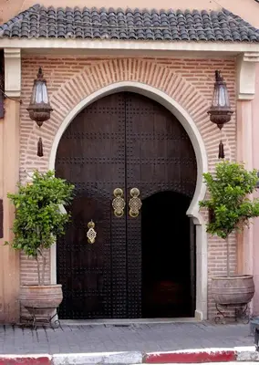 a large brown door with two plants in front of it at La Villa des Orangers - Relais & Châteaux in Marrakech