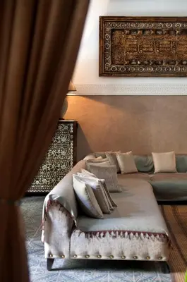 a bedroom with a bed and a couch with pillows at La Villa des Orangers - Relais & Châteaux in Marrakech