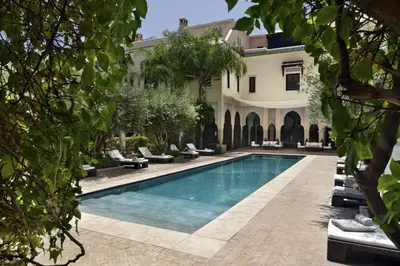 a swimming pool in front of a house at La Villa des Orangers - Relais & Châteaux in Marrakech