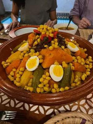 a plate of food with eggs and vegetables on a table at Riad Dalla Santa in Marrakech