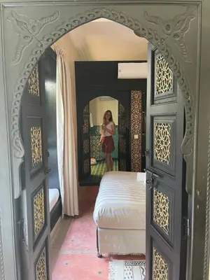 a woman standing in front of a bedroom with a bed at Riad Dalla Santa in Marrakech