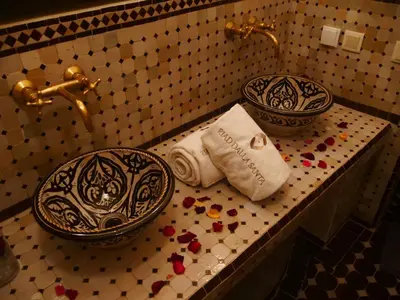 a bathroom with a sink and towels on a counter at Riad Dalla Santa in Marrakech