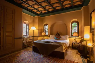 a bedroom with a bed and two windows at Riad Hizad in Marrakech