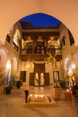 a large building with a fire pit in a courtyard at Riad Hizad in Marrakech