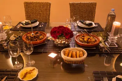 a table with plates of food and wine glasses at Riad Hizad in Marrakech