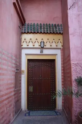 a red door with a clock on top of it at Riyad Al Moussika in Marrakech