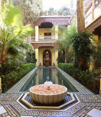 a pool in the middle of a building with a fountain at Riyad Al Moussika in Marrakech