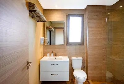 a bathroom with a toilet and a sink and a window at Darkech Prestigia Luxury Apt in Marrakech