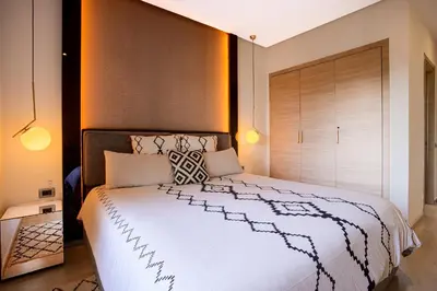 a bedroom with a large white bed in a room at Darkech Prestigia Luxury Apt in Marrakech